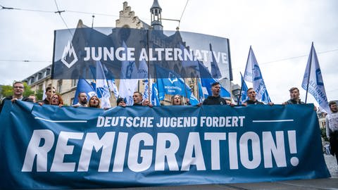 Die Junge Alternative während einer Demonstration der AfD im Oktober 2023 in Erfurt. Auf zwei großen Transparenten ist zu lesen: "Junge Alternative", davor "Deutsche Jugend fordert Remigration!"