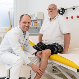 Dr. Daniel Martin (l.) kontrolliert, ob die bei Gerald Jenert eingesetzte Elektrode, die den chronischen Knieschmerz deutlich mindert, richtig sitzt und funktioniert.