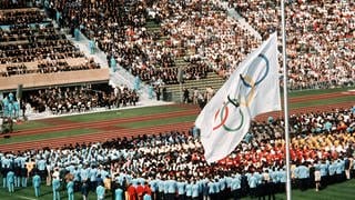 Trauerfeier am 6.9.1972 im Münchner Olympiastadion für die Opfer des Terror-Anschlages bei den Olympischen Sommerspielen. Die weiße Olympia-Flagge mit den fünf bunten Ringen hängt auf Halbmast.