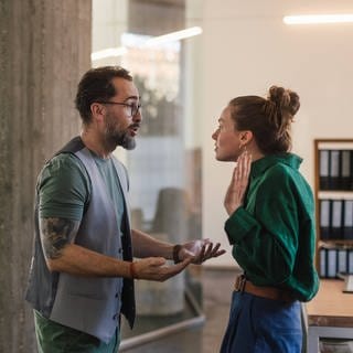 Ein Mann und eine Frau diskutieren im Büro.