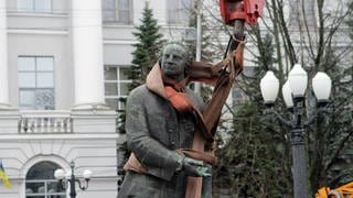 Das Denkmal für den russischen Wissenschaftler Michail Lomonossow wird im Januar 2023 in Dnipro im Osten der Ukraine mithilfe von Spezialgeräten gemontiert. Seit dem Beginn des russischen Angriffskriegs im Februar 2022 verbannt die Ukraine russische Symbole und Kultur aus Schulen, Bibliotheken und dem öffentlichen Raum. 