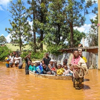 Eine Familie mit einem Boot vor einer Hütte im April 2024 im Überschwemmungsgebiet Githurai in Nairobi, Kenia. Extreme Wetterereignisse haben in den letzten drei Jahren Teile Afrikas heimgesucht und zu tropischen Stürmen, Überschwemmungen und Dürre geführt sowie Hungerkrisen und Vertreibung. Eine weitere Bedrohung: einige der schlimmsten Cholera-Ausbrüche auf dem Kontinent. In Süd- und Ostafrika sind seit Ende 2021 mehr als 6.000 Menschen gestorben und fast 350.000 Fälle gemeldet worden. 