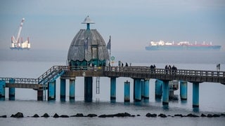 Die Offshore-Arbeitsplattform "JB119" und der LNG-Tanker "Seapeak Hispania" im März 2023 auf der Ostsee vor dem Ostseebad Sellin: Schon heute ist fast jeder Quadratkilometer der deutschen Ostsee verplant und der Druck auf das kränkelnde Meer nimmt weiter zu. Schifffahrt und Fischerei verlangen Platz. Für die Energiewende sollen weitere Offshore-Windparks errichtet werden. Und Umweltorganisationen fordern größere Meeresschutzgebiete. 