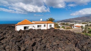 Auf der Kanarischen Insel La Palma ist ein Haus von Lava eingeschlossen. Der Vulkanausbruch auf La Palma 2021 dauerte vom 19. September bis zum 13. Dezember 2021. Was kann die Wissenschaft beitragen, um Menschen und Siedlungen vor Vulkanausbrüchen zu schützen?