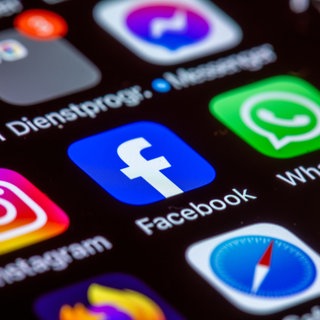 Die Apps Instagram, Facebook und WhatsApp sind auf dem Display eines Smartphones zu sehen. 