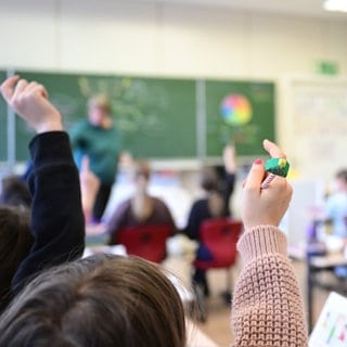 Schüler melden sich in einer vierten Klasse in einer Grundschule in Stuttgart.