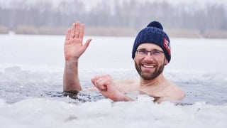 Eisbader Mario geht bei Minusgraden mit Mütze ins Wasser. Mario hatte sich mit dem Beil ein Loch in die circa 10 cm dicke Eisdecke geschlagen und geht nun drei mal hintereinander für kurze Zeit in den Habermannsee: Dass Kälte gut für den Körper sein kann, wusste schon Sebastian Kneipp. Mittlerweile gibt es viele Menschen, die auch im Winter in Seen und Meeren schwimmen. Sportler schätzen ein Eisbad, um Muskelschäden schneller heilen zu lassen. Kältetherapien sollen die Schmerzen bei Rheuma oder Migräne lindern. 