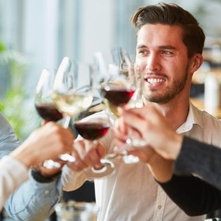 Freunde stoßen an mit Wein im Restaurant 