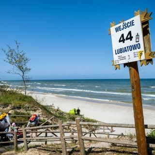 Strandschild in Lubiatowo mit Atomstopp-Aufkleber, wenige Kilometer vom geplanten Bau eines Kernkraftwerks in der Gemeinde Choczewo entfernt. Touristen und Sommerhausbewohner protestieren, doch die alteingesessene Bevölkerung erhofft sich wirtschaftlichen Aufschwung vom ersten Atomkraftwerk Polens.