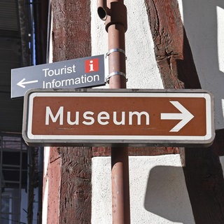 Wegweiser zum Museum und zur Touristeninformation vor der alten deutschen Fachwerkwand