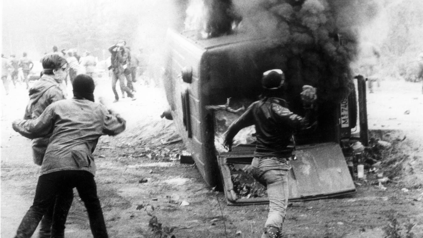 Rund 200 zum Teil vermummte Demonstranten griffen am 20. Mai 1986 in Wackersdorf an einer Zufahrtstraße eine Polizeikontrolle an, warfen diesen Mannschaftswagen um und setzten ihn in Brand.