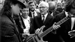 Rockmusiker Udo Lindenberg (links) überreicht SED-Generalsekretär Erich Honcker bei dessen Besuch in Wuppertal am 9. September 1987 eine Gitarre mit der Aufschrift "Gitarren statt Knarren"