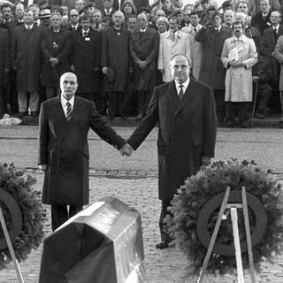 Der französische Staatspräsident Francois Mitterrand (links) und Bundeskanzler Helmut Kohl reichen sich am 22.9.1984 über den Gräbern von Verdun die Hand