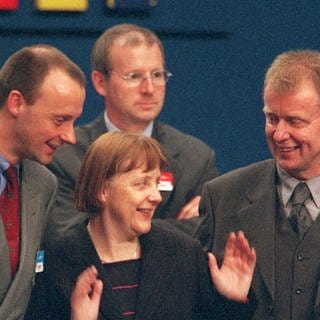 Der CDU-Fraktionvorsitzende Friedrich Merz (links) und der neue Generalssekretär Ruprecht Polenz (rechts) unterhalten sich auf dem CDU-Parteitag am 10.4.2000 in Essen mit CDU-Chefin Angela Merkel. Die 45-Jährige wurde als erste Frau zur Vorsitzenden gewählt.