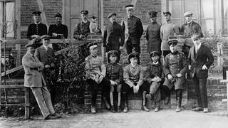 August Euler (1868 - 1957, hier mit Brille) mit Schülern der von ihm gegründeten Fliegerschule in Griesheim bei Darmstadt, neben ihm (mit Hund) Prinz Heinrich von Preußen. Foto um 1910