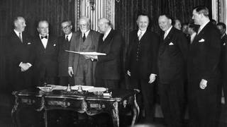 Die sechs Außenminister haben sich am 18.4.1951 nach der Unterzeichnung des Vertrags über die Europäische Gemeinschaft für Kohle- und Stahl (Montanunion) zu einem Gruppenfoto aufgestellt. (v.l.): Paul van Zeeland (Belgien), Joseph Bech (Luxemburg), nicht identifiziert, Graf Carlo Sforza (Italien), Robert Schuman mit dem Dokument (Frankreich),  Bundeskanzler und Außenminister Konrad Adenauer (Deutschland), Dirk Stikker (Niederlande), nicht identifiziert