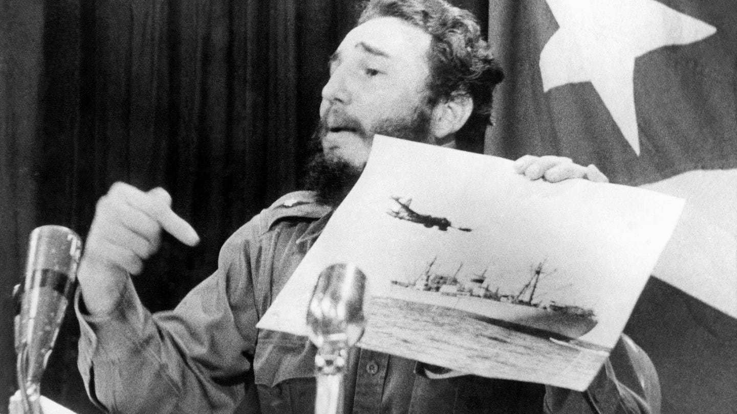 Fidel Castro, Ministerpräsident von Kuba, deutet während eines Fernsehauftritts in Havanna auf ein Foto mit einem US-Aufklärungsflugzeug und einen sowjetischen Frachter
