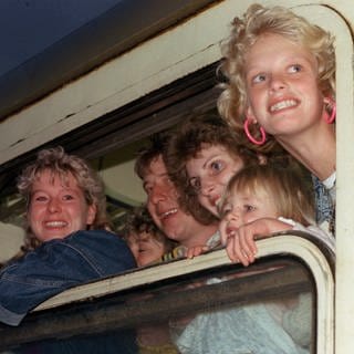 DDR-Übersiedler am 5. Oktober 1989 bei ihrer Ankunft auf dem Bahnhof im bayerischen Hof. Sie kamen mit Sonderzügen der Deutschen Reichsbahn aus Prag, wo sie auf dem Gelände der Deutschen Botschaft auf eine Einreisemöglichkeit in die Bundesrepublik gewartet hatten. Züge aus Prag, die beim Durchqueren des DDR-Gebietes durch Dresden gefahren waren, hatten große Unruhe bei den DDR-Bürgern ausgelöst. Ausreisewillge hofften, auf einen der Züge aufspringen zu können.