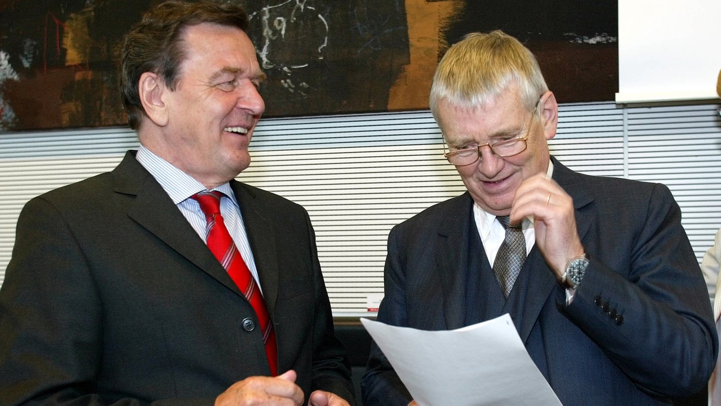 Bundeskanzler Gerhard Schröder (links) und Innenminister Otto Schily lesen vor Beginn der SPD-Fraktionssitzung in Berlin am 25. Mai 2004 Dokumente: Der Kanzler führt Gespräche mit der Opposition für eine Einigung zum geplanten Einwanderungsgesetz.