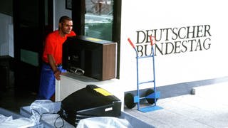 Regierungsumzug von Bonn nach Berlin im Juli 1999: Ein Umzugshelfer räumt Fernsehgeräte aus einem Verwaltungsgebäude in Bonn