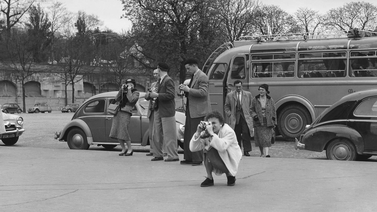 Reisebus und fotografierende Touristen vor dem Eiffelturm in Paris im 9. April 1955