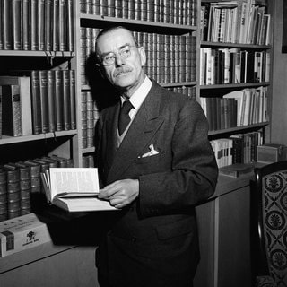 Schriftsteller Thomas Mann im April 1945 in seinem Haus in Santa Monica in Kalifornien  USA vor einem Bücherregal: Die Konferenz von Jalta im Februar 1945 nahm er zum Anlass, sich aus seinem kalifornischen Exil mit einer Rundfunkbotschaft über das deutsche Programm der BBC an die deutschen Hörer zu wenden.