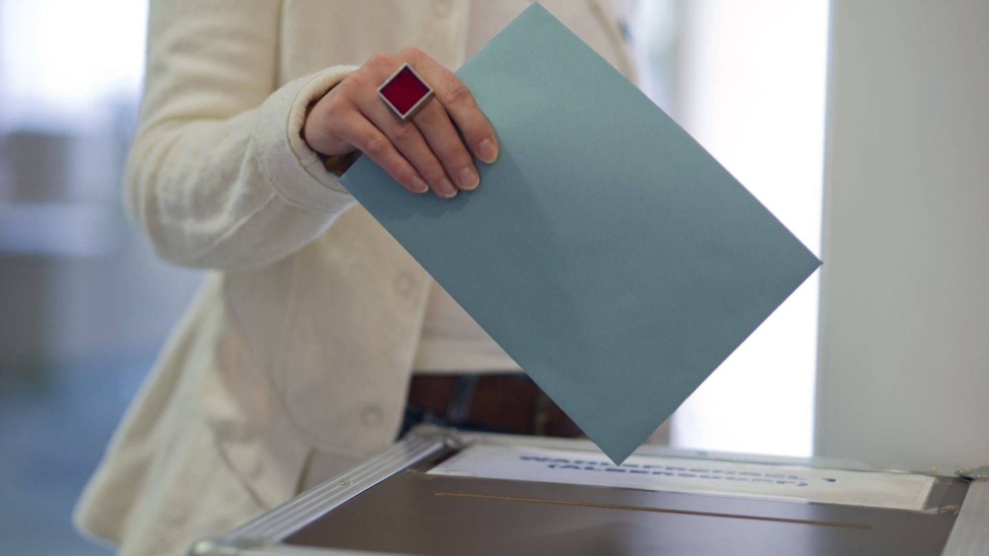 Frau wirft Stimmzettel in Wahlurne