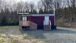 Ein Baucontainer steht trostlos auf einer leeren Fläche. Hier soll eine Wald-Kita in SchwollenRheinland-Pfalz entstehen.