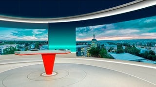 Ein roter Tisch steht vor zwei Panoramawänden im neuen Studio in Mainz von SWR Aktuell Rheinland-Pfalz