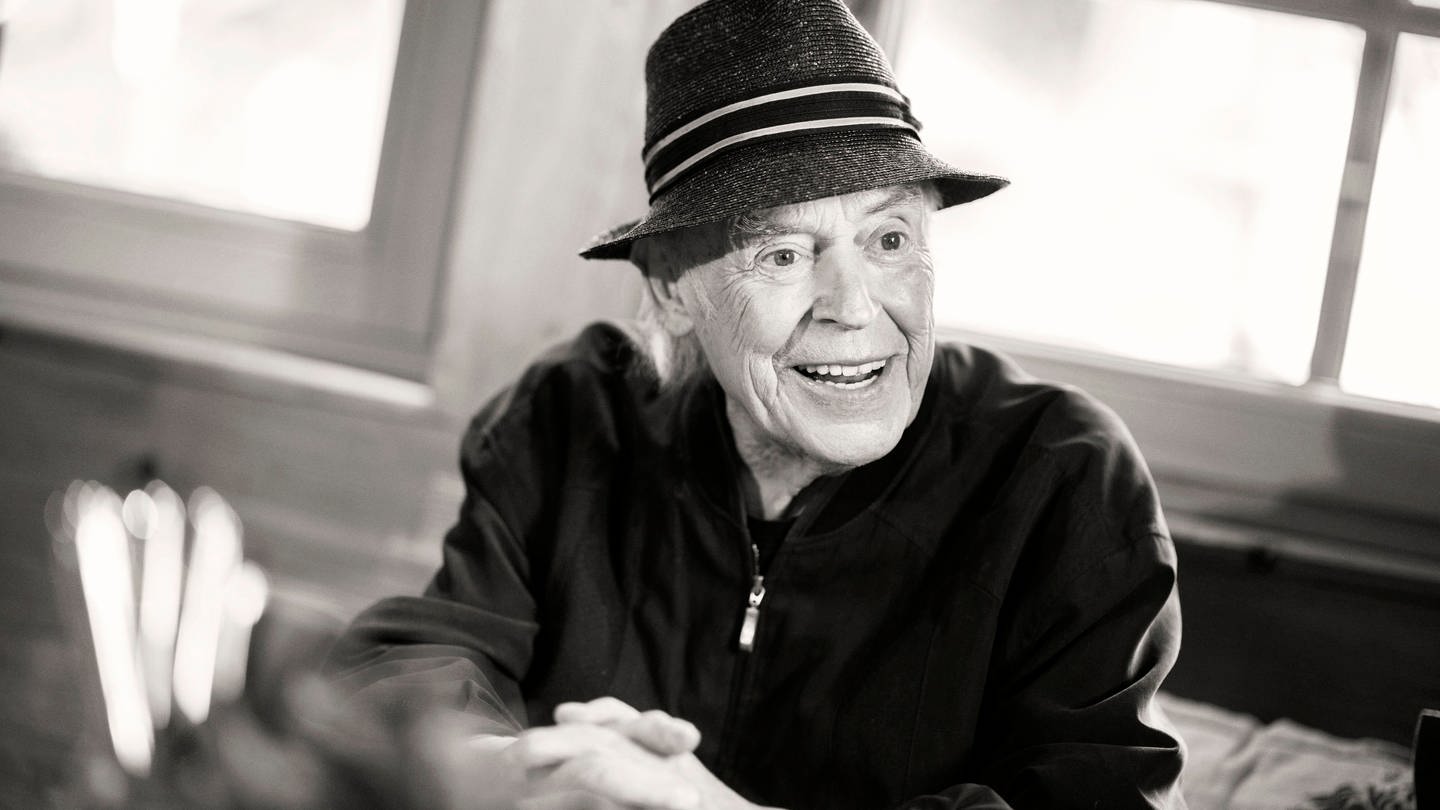 Schwarzweißfoto des verstorbenen Schlagersängers Tony Marshall. Marshall lachend mit Hut.