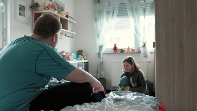 Der schwerstbehinderte Aron (21) schaut zu, wie seine jüngere Schwester Helena die Spielsachen für den anstehenden Umzug in eine Wohngruppe packt.