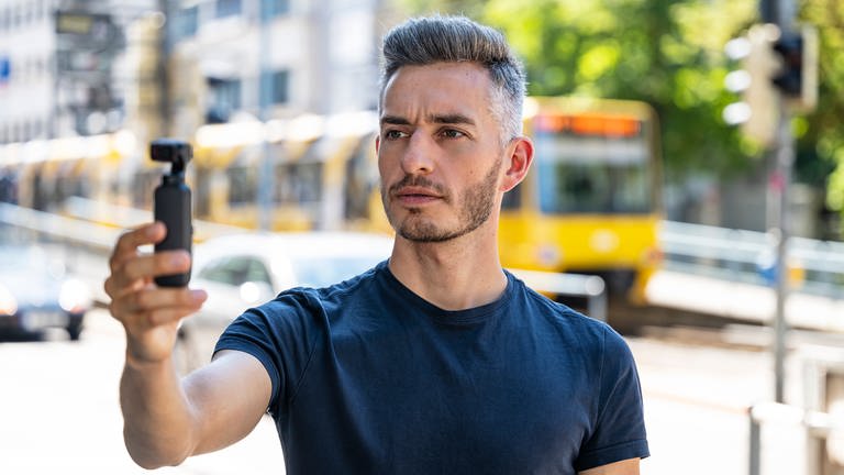 Marvin Neumann ist Host der Reihe "SWR Aktuell - 360 Grad". Auf dem Bild filmt er mit einer kleinen Kamera sich und seine Umgebung.