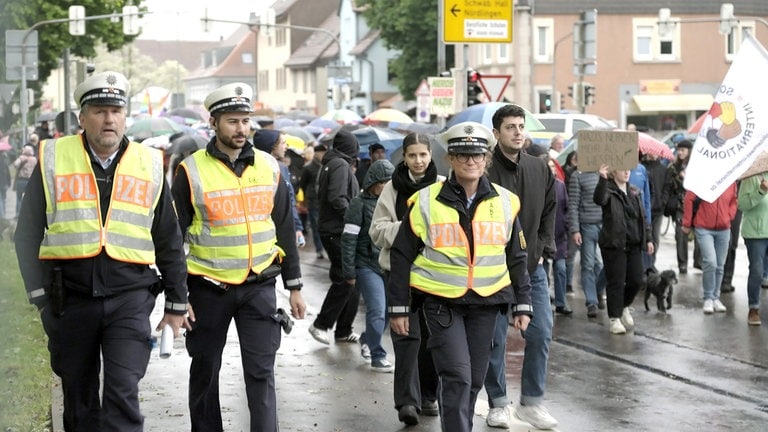 Drei Polizist:innen bei der Anti-AfD Demo auf der Straße