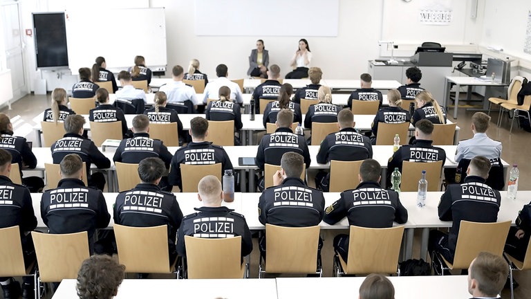 Polizisten der Polizeihochschule Baden-Württemberg in einem Unterrichtsraum von hinten fotografiert