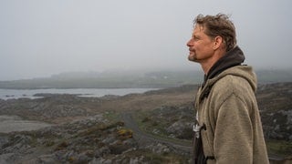 Lars vor dem rauen schottischen Panorama nachdenklich blickend