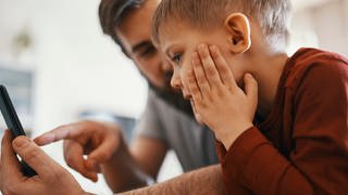 Vater und Sohn mit einem Smartphone