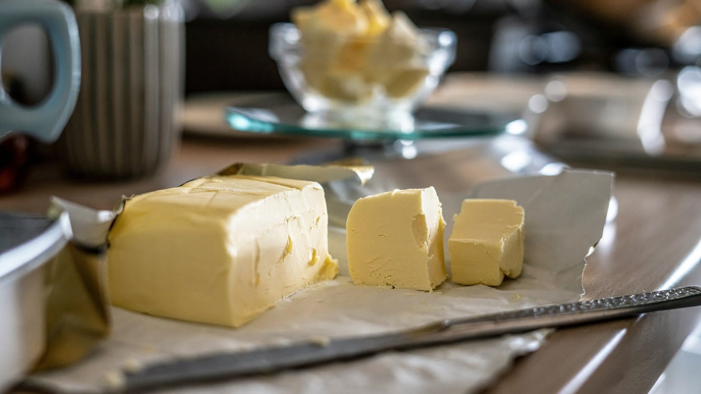 Ein Stück Butter liegt auf einem Frühstückstisch.