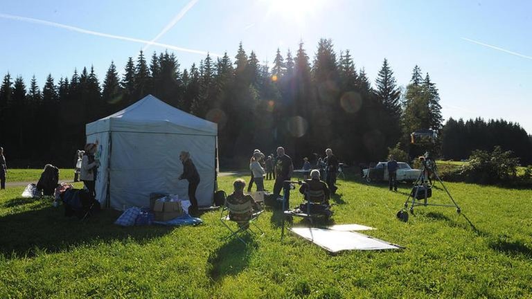 Filmteam bei Dreharbeiten auf einer Wiese