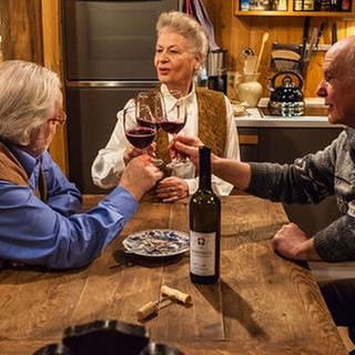 Hermann, Johanna und Heinz stoßen mit Rotwein an