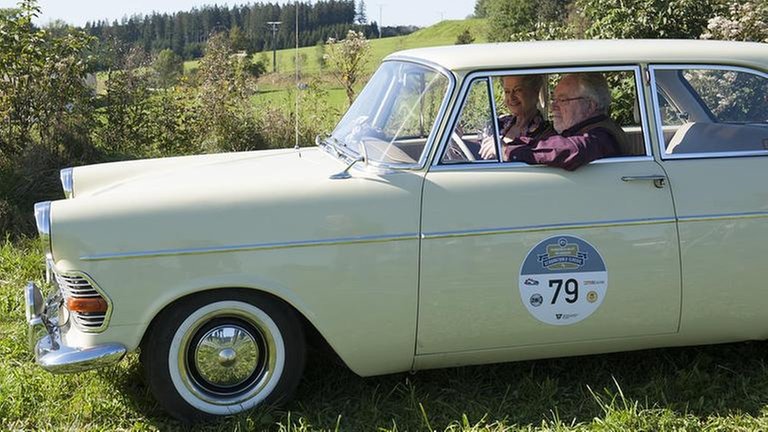 Johanna und Hermann sitzen in ihrem Oldtimer