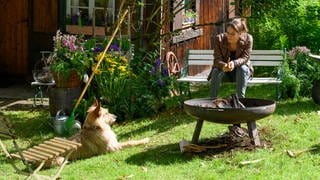 Franziska Hecker mit ihrem Hund Ramses vor ihrer Waldhütte