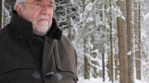 Hermann steht im Schnee vor dem Wald