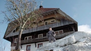 Sebastian steht vor dem Fallerhof im Schnee und sieht in die Ferne