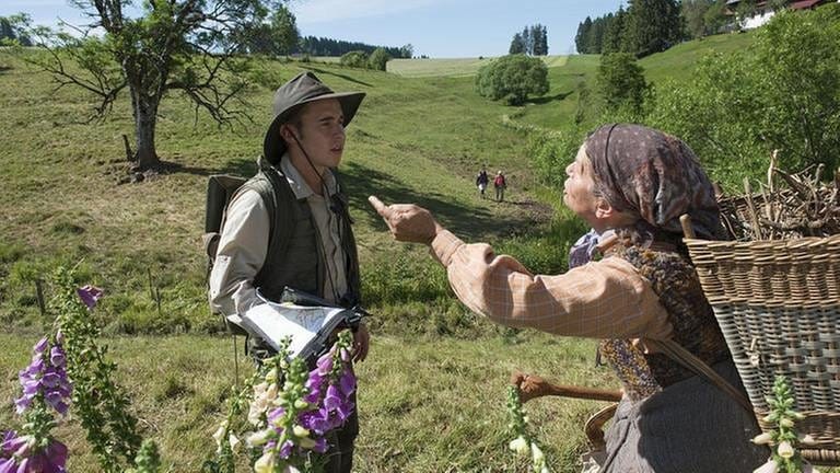 Sebastian und Lioba im Streitgespräch, im Hintergrund der Fallerhof und Wanderer