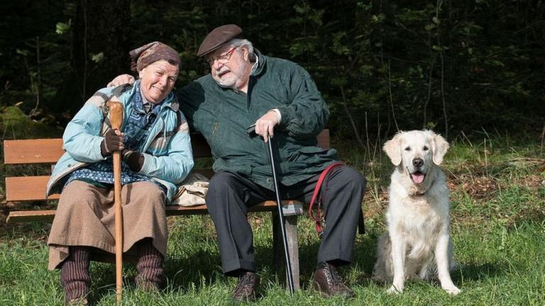 Lioba und Hermann sitzen auf einer Bank am Waldrand