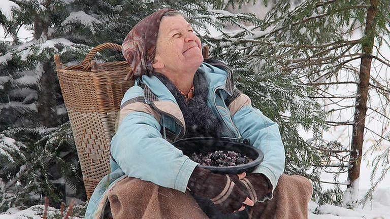 Lioba sitzt im Schnee und freut sich