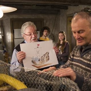 Karl arbeitet im Brunnengang, Hermann zeigt ihm ein Bild, im Hintergrund stehen Albert und Lena