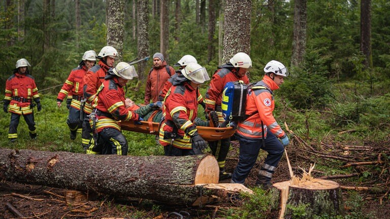 Feuerwehrleute transportieren einen Verletzten ab