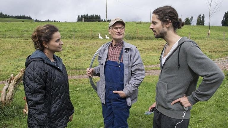 Jenny, Karl und Albert stehen auf der Wiese und sprechen