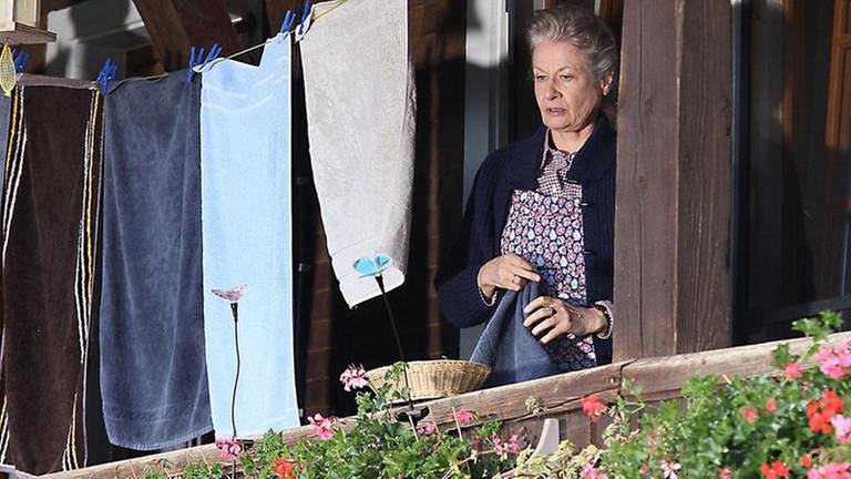 Johanna steht auf dem Balkon des Fallerhofes, neben ihr Wäsche an der Wäscheleine